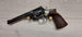 Vintage revolver with wooden grip and brass cartridges, ideal for collectors and shooting sports.