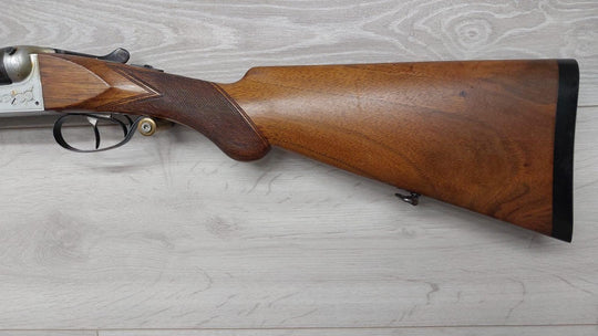 Classic wood-stocked shotgun with engraved receiver, ideal for hunting or collecting
