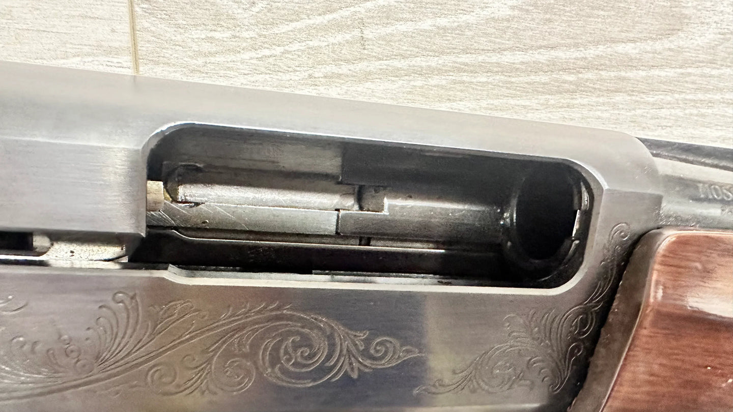 Close-up of engraved rifle action with wooden stock, ideal for collectors and hunting