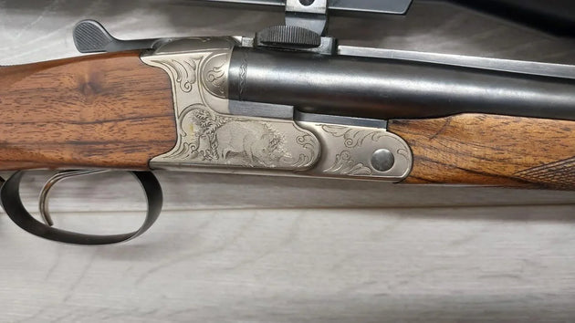 Finely engraved hunting rifle with ornate metalwork and wooden stock, ideal for collectors and sport shooting.