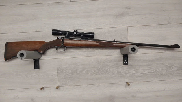 Wooden stock rifle with scope, displayed on foam rests, ideal for hunting or target shooting.