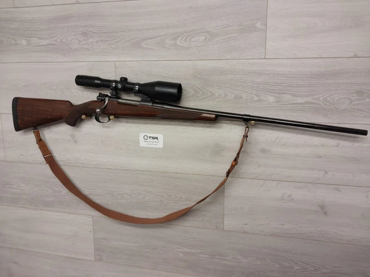 Bolt-action rifle with scope and leather sling, ideal for hunting and sport shooting
