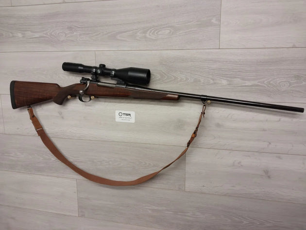 Bolt-action rifle with scope and leather sling, ideal for hunting and sport shooting