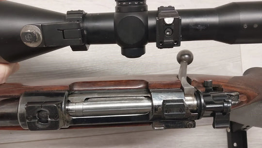 Bolt-action rifle with mounted scope, wooden stock, and metal receiver for hunting or sport shooting