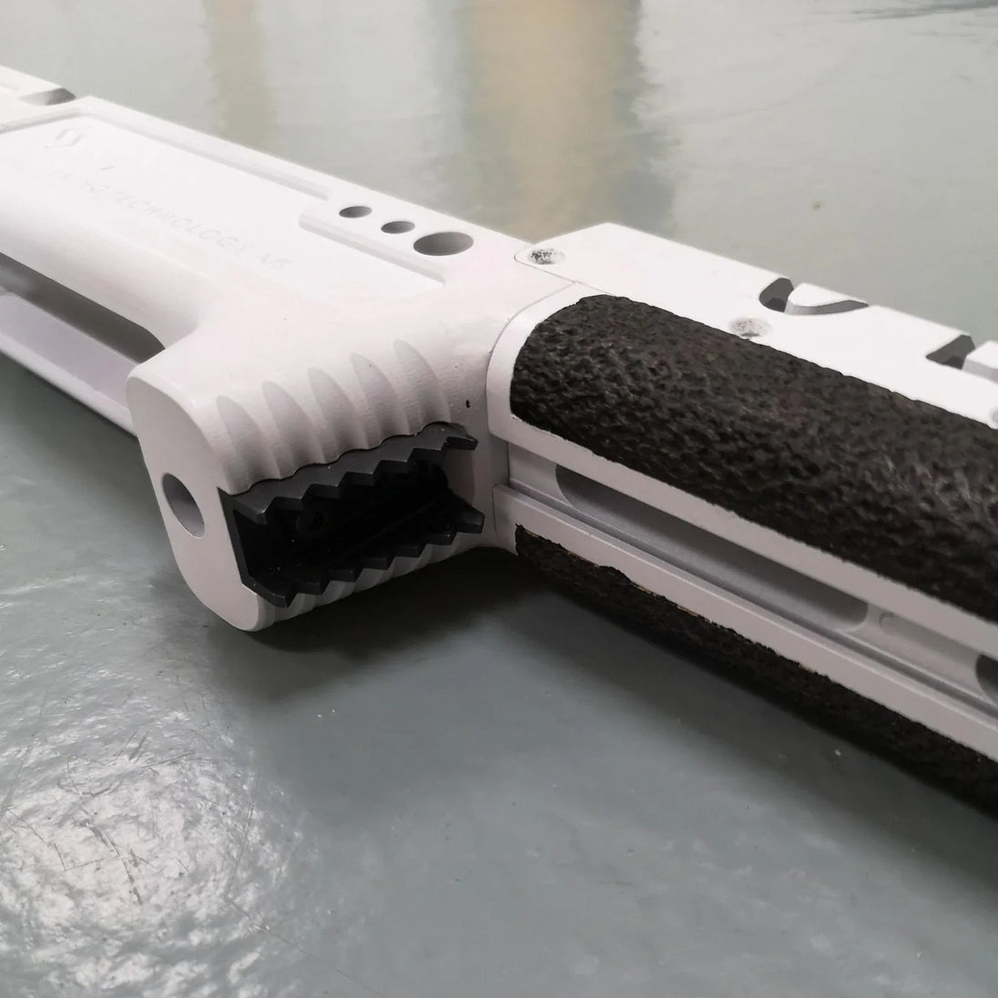 White tactical rifle stock with black textured grip, designed for precision shooting and competition use.