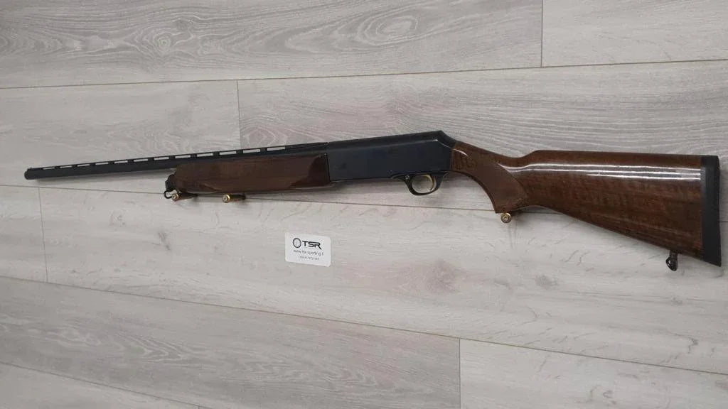 Used hunting shotgun with wooden stock displayed on wall, ideal for sport shooting and collection