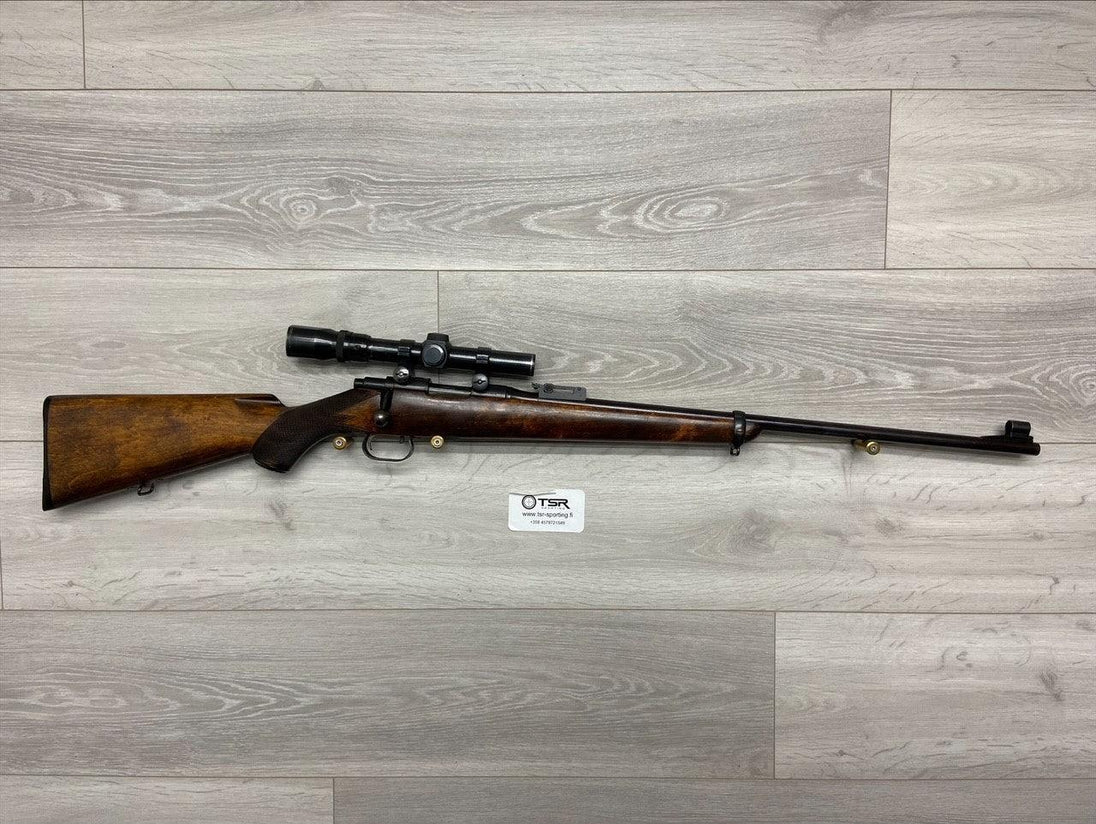 Bolt-action rifle with scope, wooden stock, for hunting or sport shooting on gray wood floor