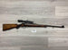 Bolt-action rifle with scope, wooden stock, for hunting or sport shooting on gray wood floor