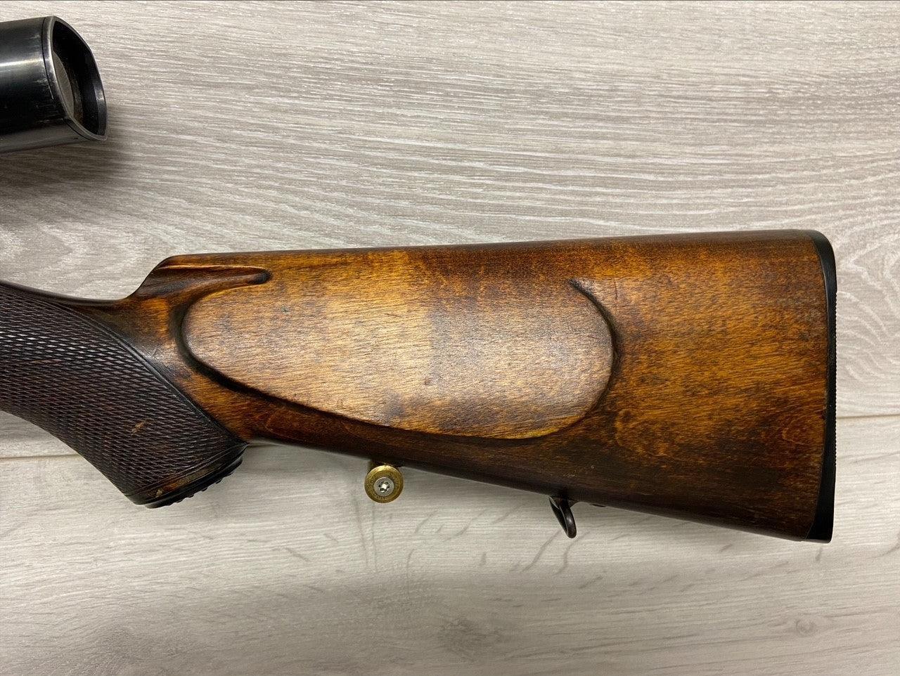 Wooden rifle stock with cheek rest and brass cartridge, for hunting or sport shooting