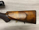 Wooden rifle stock with cheek rest and brass cartridge, for hunting or sport shooting