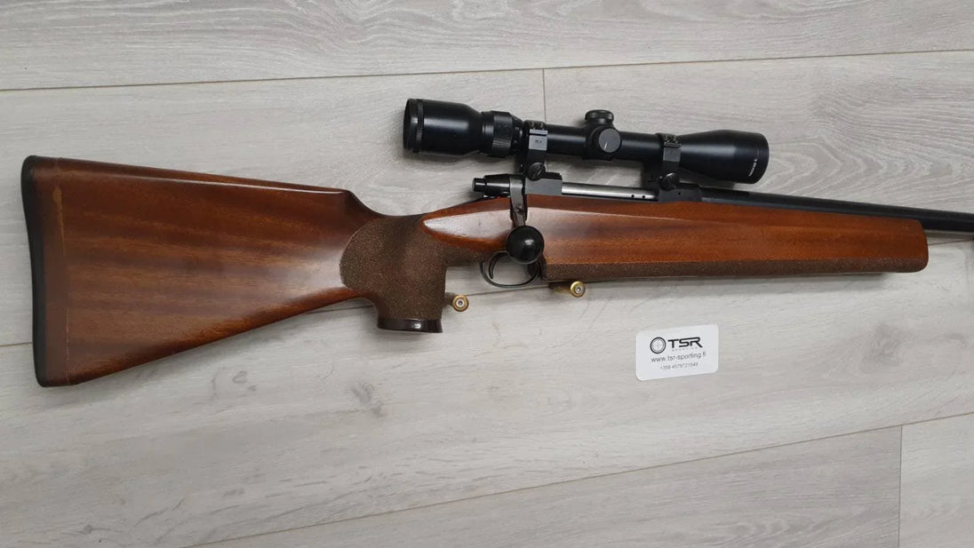 Wooden stock rifle with scope, ideal for hunting and target shooting, displayed on light wood floor.