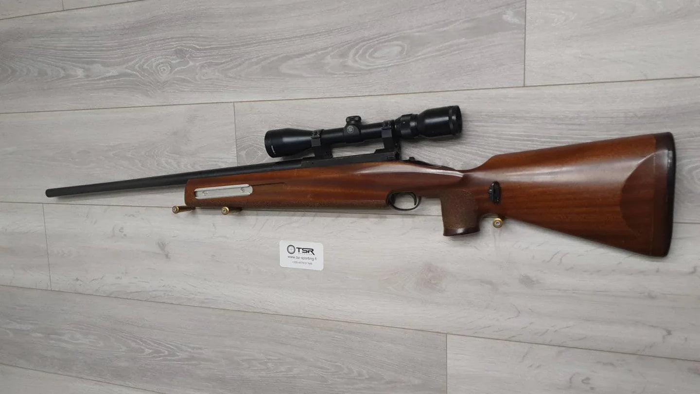 Wooden stock rifle with scope, ideal for hunting or sport shooting, displayed on wood floor.
