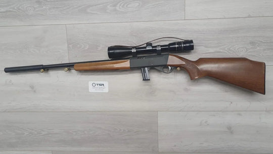 Wooden stock rifle with scope, ideal for hunting and target shooting, displayed on light wood floor.