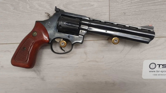 Taurus .357 Magnum revolver with wood grip, displayed with ammo on light wood surface for sale