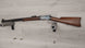 Vintage lever-action rifle with wooden stock displayed on wall mount, ideal for collectors and hunting enthusiasts.