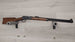 Classic lever-action rifle with wooden stock displayed on wall mount, ideal for hunting or collection.