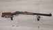 Classic lever-action rifle with wooden stock displayed on wall mount, ideal for hunting or collection.