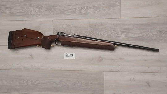 Wooden stock rifle for hunting or sport shooting, displayed on light wood floor