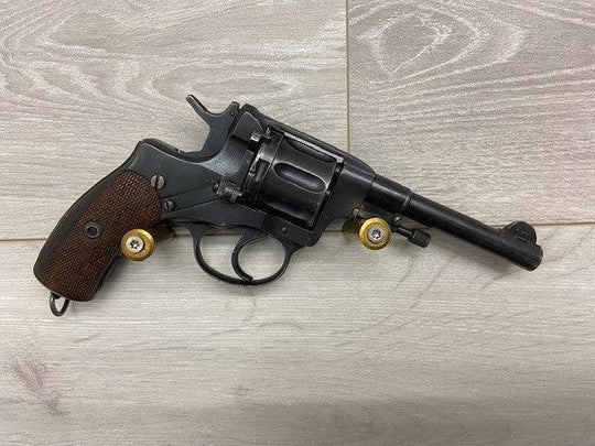 Vintage revolver with wooden grip and brass cartridges, ideal for collectors and shooting sports